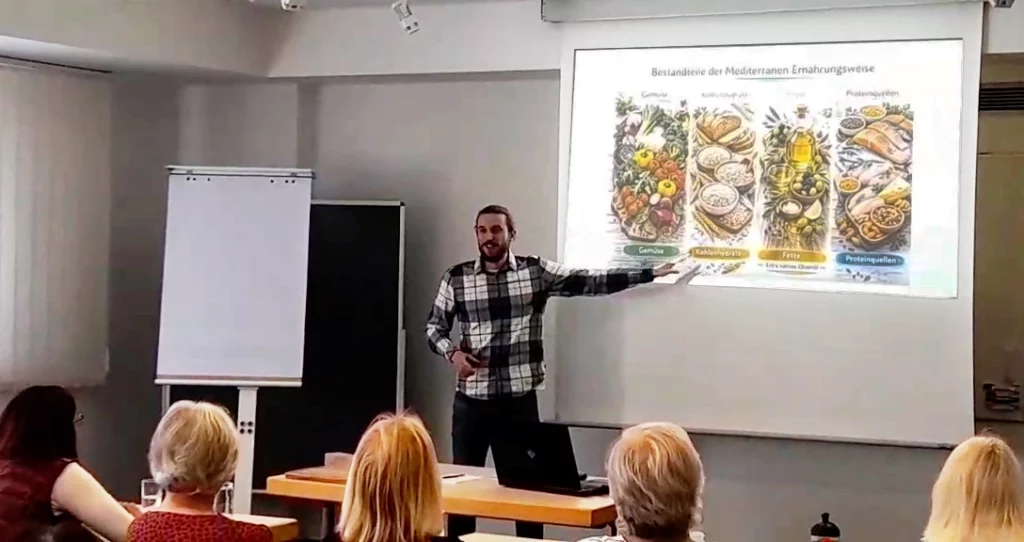 Niclas Reiber erklärt Inhalte zur entzündungshemmenden Ernährung und zeigt dabei auf eine Präsentationsfolie